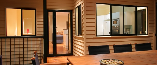 Exterior view of a home featuring a security door and window. The security door is black framed glass. Home security solutions.